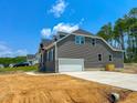 View of the house highlighting the two-car garage and the newly paved driveway, nestled on a construction lot at 403 Duncan Creek Rd # 131, Lillington, NC 27546