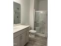 Bright bathroom featuring a modern vanity, a toilet, and a glass-enclosed shower at 702 Portia Way, Homesite 16, Morrisville, NC 27560