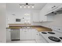 Cozy kitchen featuring white cabinetry, stainless steel appliances, and an open view to the living room at 2248 Ventana Ln, Raleigh, NC 27604