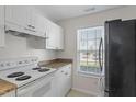 Well-lit kitchen featuring white cabinets, laminate counters, stainless steel appliances, and a window at 2248 Ventana Ln, Raleigh, NC 27604
