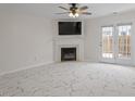 Bright living room featuring a fireplace, marble floors, and french doors leading to a patio at 2248 Ventana Ln, Raleigh, NC 27604