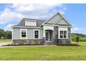 Home with attractive stone facade, green lawn, and 'Available' sign at 261 Kissington Way, Benson, NC 27504