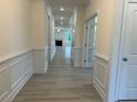 Inviting hallway with white trim, neutral walls, and wood-look floors creates a bright and spacious entry at 261 Kissington Way, Benson, NC 27504