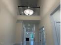 High ceiling hallway with white trim, a view of the front of the home, and a modern chandelier at 261 Kissington Way, Benson, NC 27504