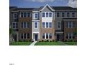 Charming townhome showcasing a brick and siding exterior with well-manicured landscaping at 303 Chesapeake Cmns St # 99, Garner, NC 27529