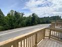 Property with a deck and view of the street and nearby trees at 303 Chesapeake Cmns St # 99, Garner, NC 27529
