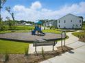 Neighborhood playground with play structure, bench, and a paved walkway at 303 Chesapeake Commons St # 99, Garner, NC 27529