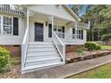 Inviting front porch with white railings and black door, enhancing the home's curb appeal at 308 Deep Creek Dr, Clayton, NC 27520