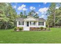 Charming single-story home with manicured lawn, mature trees, and inviting front porch at 308 Deep Creek Dr, Clayton, NC 27520