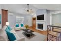 Cozy living room featuring hardwood floors, fireplace, ceiling fan, and comfortable seating at 308 Deep Creek Dr, Clayton, NC 27520