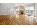 Spacious living room featuring a brick fireplace, hardwood floors, and natural light from large windows at 4701 Regalwood Dr, Raleigh, NC 27613