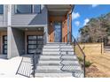 Stylish entrance with gray stone steps, a black railing, and a modern door with glass panes at 1000 Addison Pl # 101, Raleigh, NC 27610