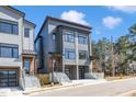 Modern townhouses boasting a gray exterior, black windows, private garages, and well-maintained surroundings at 1000 Addison Pl # 101, Raleigh, NC 27610