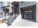 Modern townhome with a spacious driveway and inviting stairs leading to the front door at 1000 Addison Pl # 102, Raleigh, NC 27610