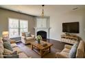 Inviting living room with a fireplace, hardwood floors, and large window for natural light at 1212 Southgate Dr, Raleigh, NC 27610