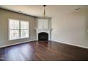 Spacious living room with a fireplace, hardwood floors, and large window for natural light at 1212 Southgate Dr, Raleigh, NC 27610