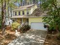 Charming yellow two-story home with a well-manicured lawn and inviting front porch and attached two car garage at 102 Pinehill Way, Cary, NC 27513