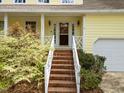 Inviting front porch with white railings, brick stairs and charming address numbers for an updated look at 102 Pinehill Way, Cary, NC 27513