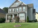 Two-story house with gray siding, stone accents, and a manicured lawn at 503 Bendemeer Ln, Rolesville, NC 27571