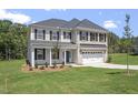 Attractive two story home with a combination brick and vinyl facade, well-manicured lawn, and attached garage at 55 New Liberty Dr, Youngsville, NC 27596