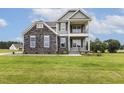 Attractive two-story home with gray siding, stone accents, and a welcoming double stacked front porch at 85 Kissington Way, Benson, NC 27504
