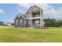 Attractive two-story home with gray siding, stone accents, and a welcoming double stacked front porch at 85 Kissington Way, Benson, NC 27504