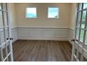 Home office featuring wainscoting, two windows, and glass French doors at 85 Kissington Way, Benson, NC 27504