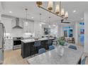 Open-concept kitchen with stainless steel appliances, large island with seating, and modern lighting at 1105 Glascock St # 102, Raleigh, NC 27610
