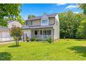 Inviting two-story home featuring a covered porch and lush green lawn at 4708 River Boat Landing Ct, Raleigh, NC 27604