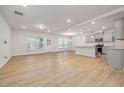 Open concept living room with hardwood floors and a view into the kitchen at 518 Donnegal Farm Dr, Fuquay Varina, NC 27526