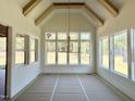 Sun-filled dining room featuring vaulted ceilings, exposed beams, a modern chandelier, and large windows at 135 Cherry Bark Dr, Youngsville, NC 27596