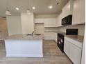 Bright kitchen features granite countertops, stainless steel sink in the island, black appliances, and wood flooring at 163 Vili Dr, Broadway, NC 27505
