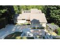 Stunning home with mature trees, featuring a stone and concrete driveway leading to its inviting entrance and well-manicured landscaping at 2213 Weybridge Dr, Raleigh, NC 27615