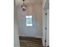View of the light-filled entryway with a modern black pendant light and a front door with glass panels at 23 Surles Landing Way, Benson, NC 27504