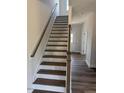 White and wood staircase featuring brown treads and a white handrail at 23 Surles Landing Way, Benson, NC 27504