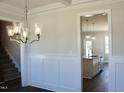 Dining room has a modern chandelier, dark wood floors, and view of the kitchen at 48 Surles Landing Way, Benson, NC 27504