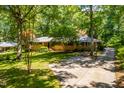 Lovely single-Gathering home with lush landscaping, a driveway, and mature trees creating curb appeal at 5205 Rembert Dr, Raleigh, NC 27612