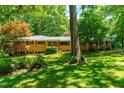 Traditional-style brick home with well-maintained lawn and mature trees, offering a serene setting at 5205 Rembert Dr, Raleigh, NC 27612