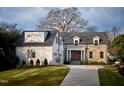 Beautiful brick and stone home with manicured lawn, attached garage, and mature landscaping at 1307 Mayfair Rd, Raleigh, NC 27608