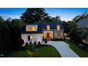 Charming two-story home with stone accents, manicured lawn, and a welcoming front entrance at dusk at 1307 Mayfair Rd, Raleigh, NC 27608
