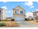 Tan two-story house with a white garage door at 2019 Tennessee Rd, Durham, NC 27704