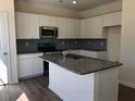 This spacious kitchen features an island, stainless steel appliances and white cabinets at 65 Vili Dr, Broadway, NC 27505