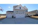 Two-story home with a three-car garage and a landscaped yard at 68 Hampshire Ct, Four Oaks, NC 27524