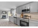 Bright kitchen showcasing stainless steel appliances, stone countertops, and a cozy fireplace at 97 Brent Wood Ct, Sanford, NC 27332