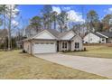 Two-car garage with a light-colored exterior and a neatly manicured lawn at 101 Prairie Dog Dr, Louisburg, NC 27549