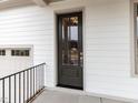 Modern front door with glass inserts, complemented by white siding and a dark-colored finish at 108 Bearwallow Forest Way, Wendell, NC 27591