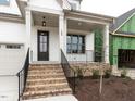 Inviting front porch featuring brick steps, black railings and a stylish front door with glass panels at 108 Bearwallow Forest Way, Wendell, NC 27591