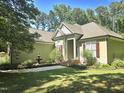 Beautiful home featuring a well-manicured lawn, mature trees, and a charming water fountain at 109 Springwood Dr, Wake Forest, NC 27587