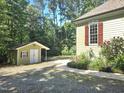 View of the house and a small outbuilding, framed by lush greenery and manicured landscaping at 109 Springwood Dr, Wake Forest, NC 27587