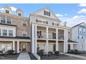 3-story townhome with front porch and gray siding at 1226 Barn Cat Way, Apex, NC 27502